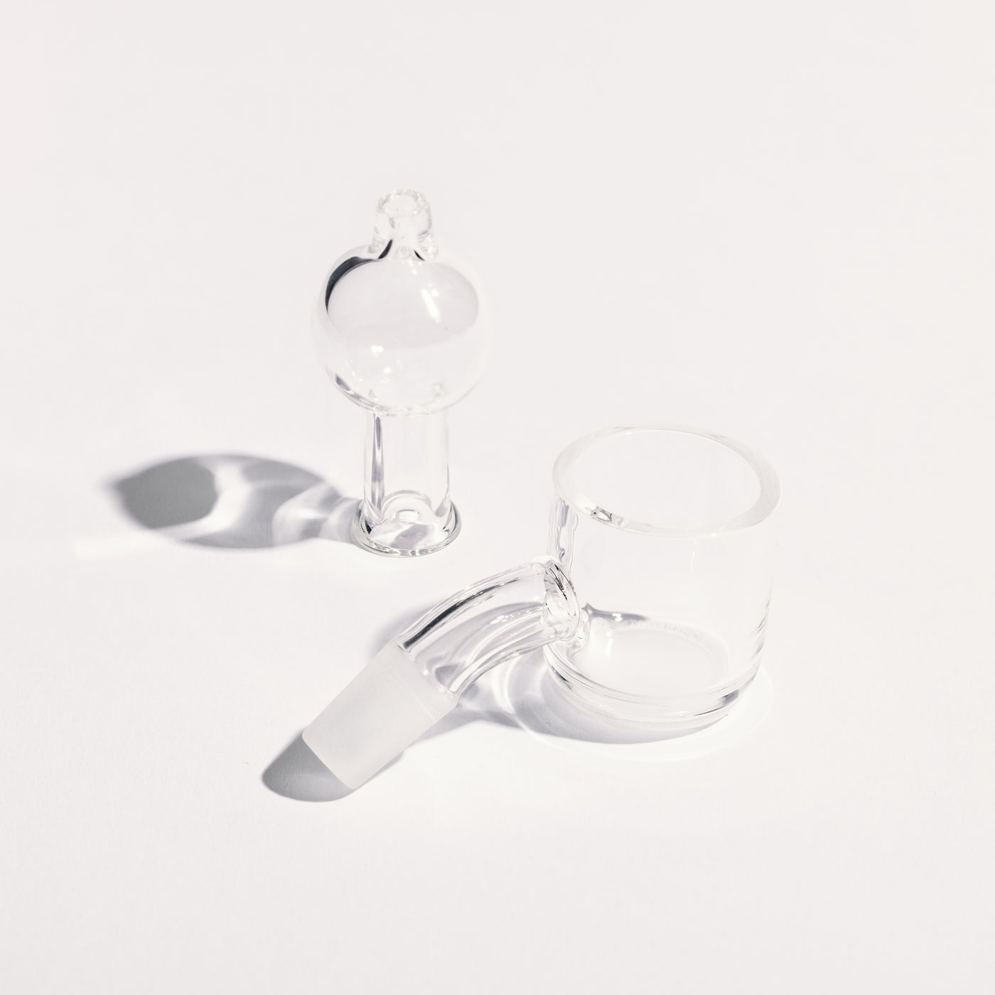 A close up of clean banger and cap, showing the high-quality quartz glass, white background