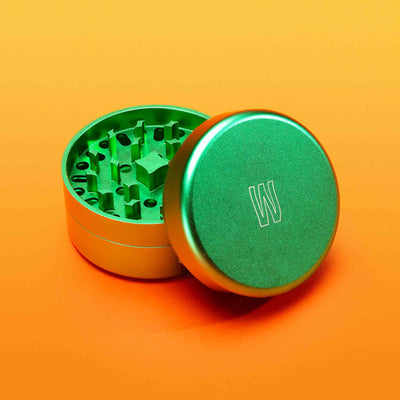 3 piece metal grinder against orange background