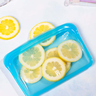 aqua blue cleaning pouch with lemons inside, white backdrop 