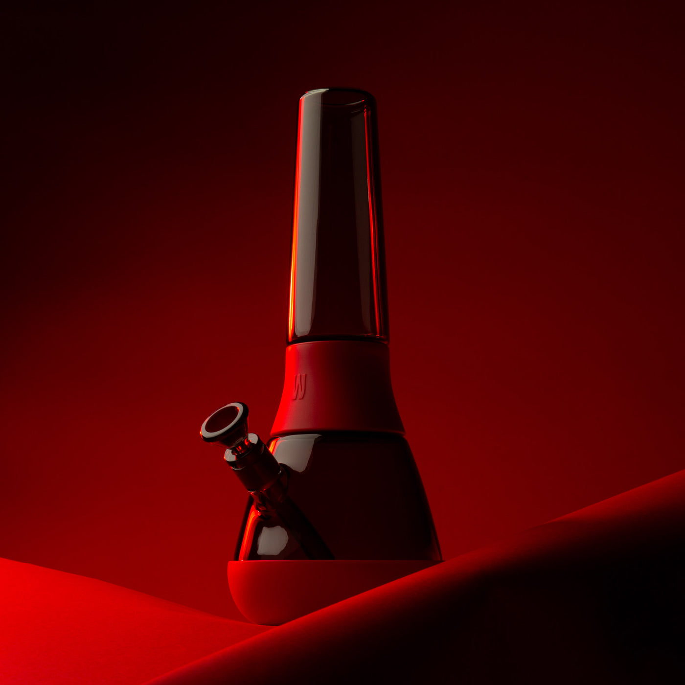 black glass bong with red cover against red background