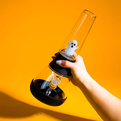 hand holding Halloween edition ghost percolator Bongs, yellow backdrop 