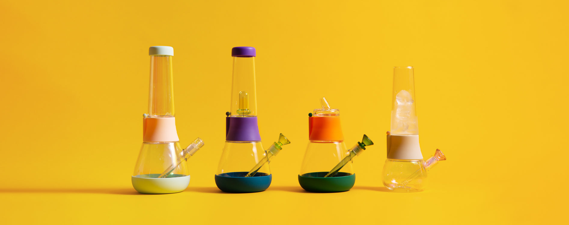 A row of custom bongs with colorful mix-and-match designs, displayed against a yellow background.