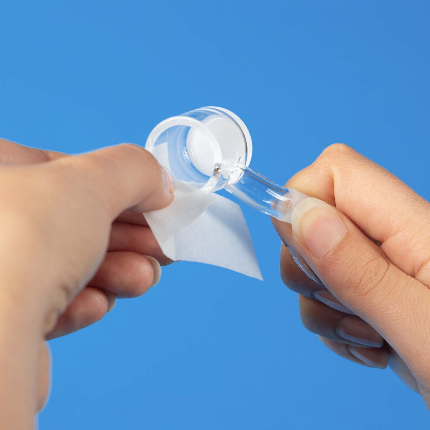 cleaning quartz banger with cleaning wipe against blue background
