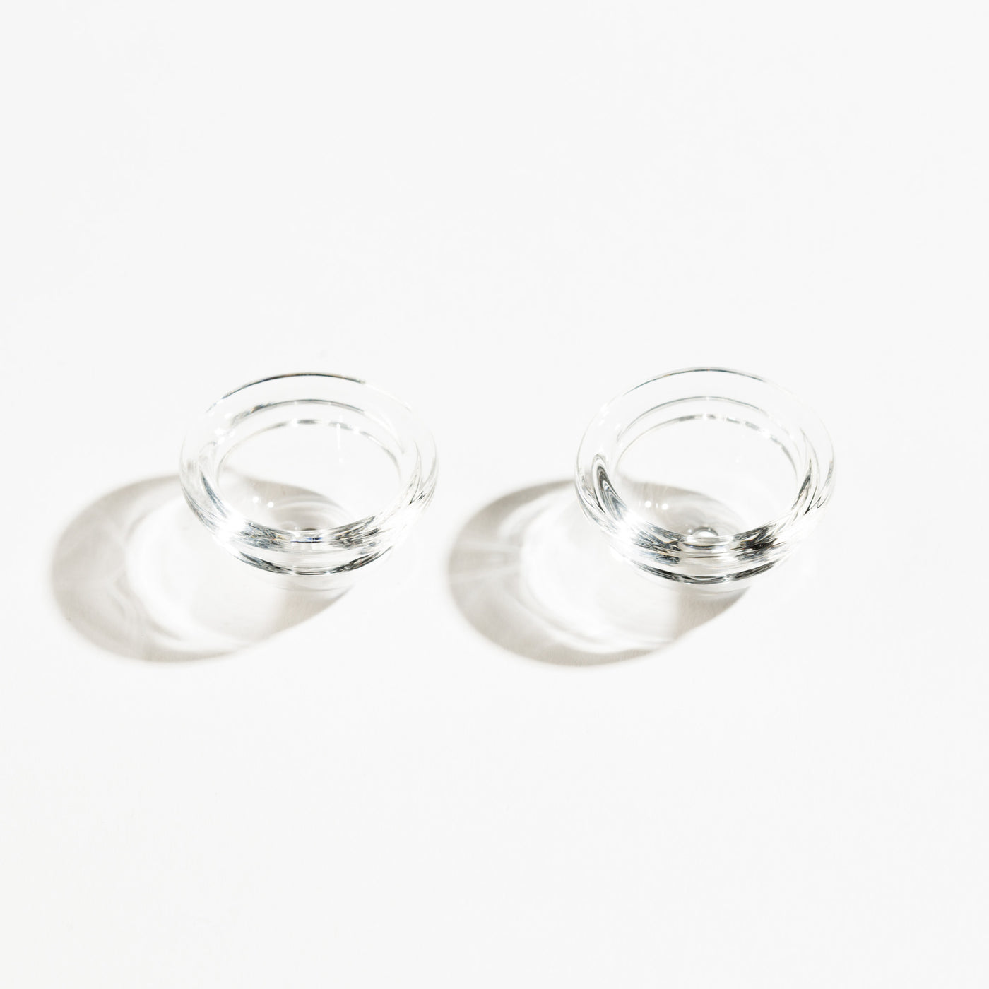 two clear glass mini pipe bowls in a white background