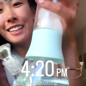 Asian customer smiling happily while holding Weeday modular bong with ice cubes