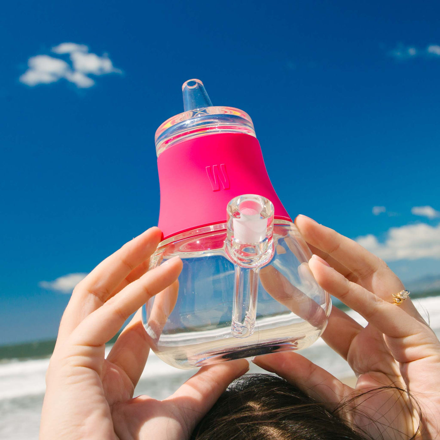 hot pink bubbler at the beach being held over the head