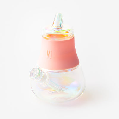 Bubblegum pink iridescent glass bubbler bong with a silicone cover, with beautiful light reflection.