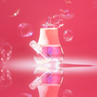 A Bubblegum Pink Iridescent Bubbler featuring a reflective studio setup with a vibrant pink backdrop and floating bubbles.