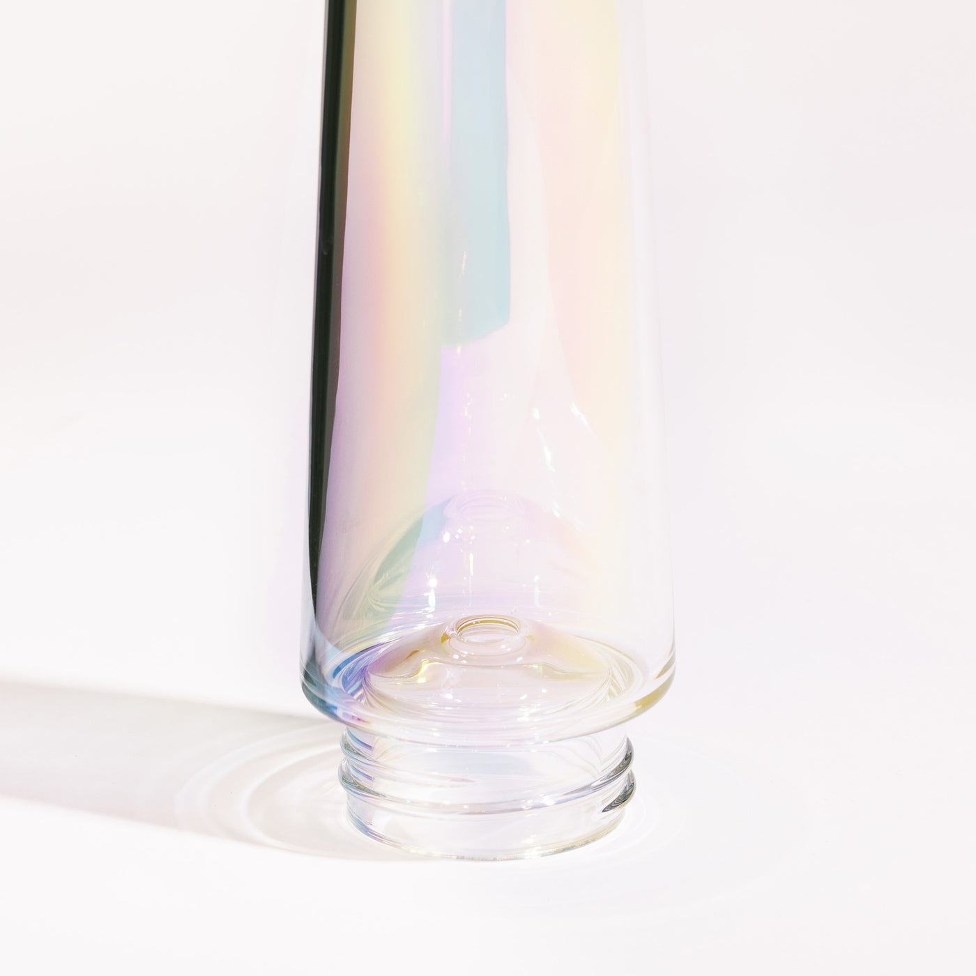 close up of Iridescent ice catcher for bongs, reflecting the light, white background