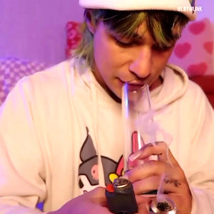 Customer wearing hoodie and beanie hat inhaling smoke with Weeday water pipe