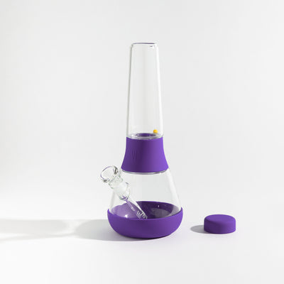 Detachable glass bong with grape purple silicone covers on a white background.