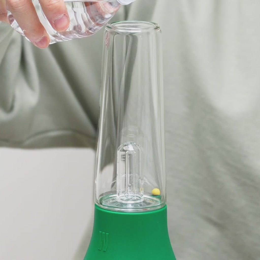 a person is pouring water inside the percolator, smoking and making bubbles 