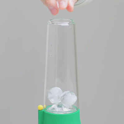 close up of hand putting ice cubes inside ice catcher, showing clear glass