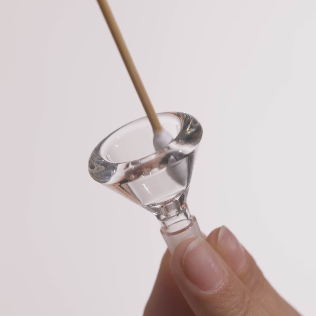 A hand using Cotton Swab to clean the bong bowl, Downstem, and bong base, showing clean high-quality glass