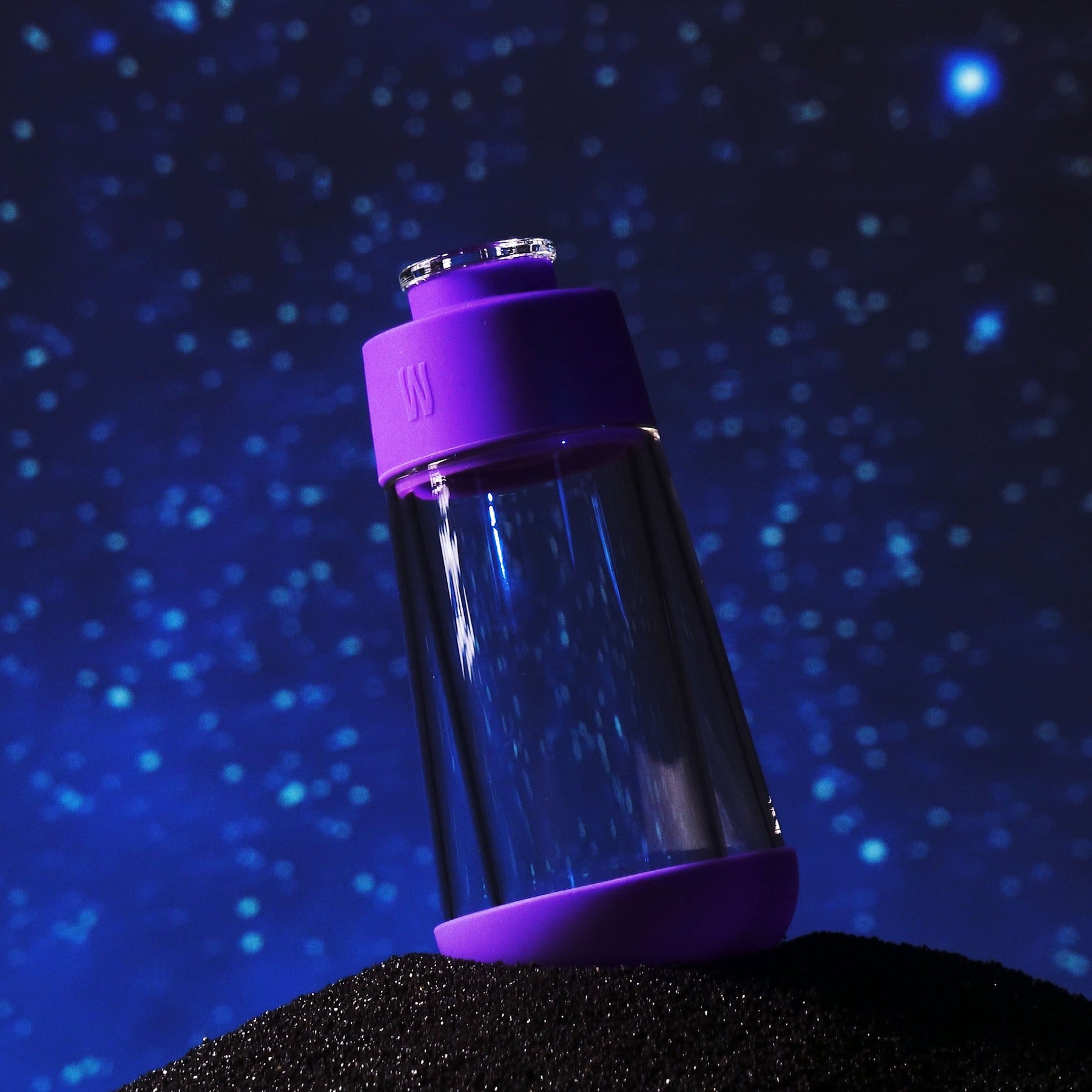 grape purple gravity bong in galaxy on top of black sand