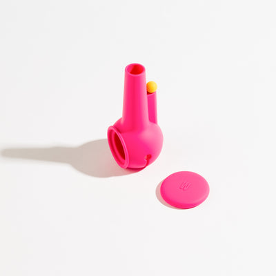 Hotpink silicone pipe protector standing in a white background with cap aside 