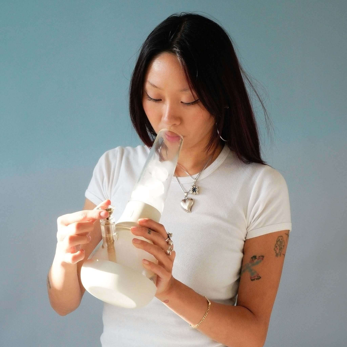 A woman using her Weeday glass bong with ice catcher tube for the smoothest session.