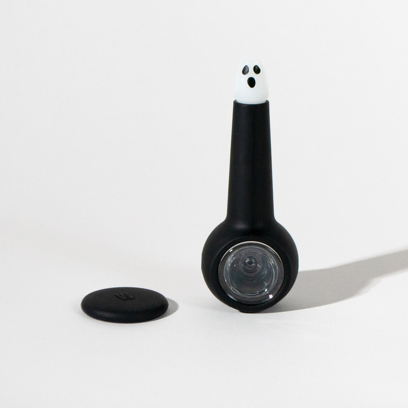 Spooky ghost pipe with black silicone cover and ghost pipe base, white background and cap separated 