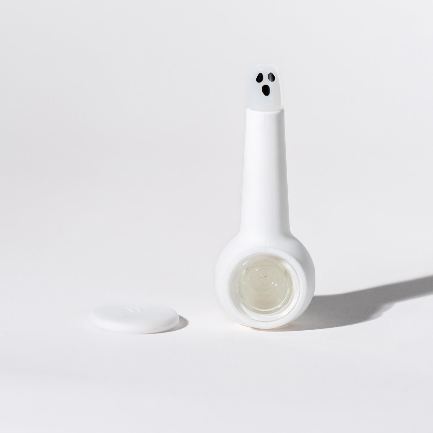 Spooky ghost pipe with white silicone cover and ghost pipe base standing, white background and Cap separated 