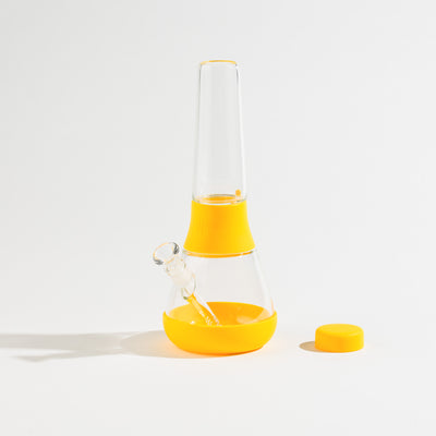 a sunshine silicone and glass bong with bong cap separated on a white background.