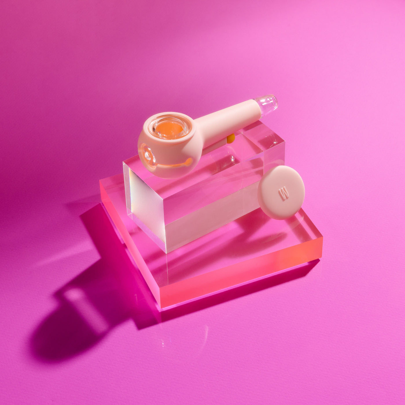 Product photo of a stylish baby pink designer pipe on a block of glowing acrylic glass, cap uncovered.