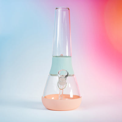 Front view of Weeday detachable bong with sky and bubblegum silicone covers, sitting against pink-blue gradient backdrop.