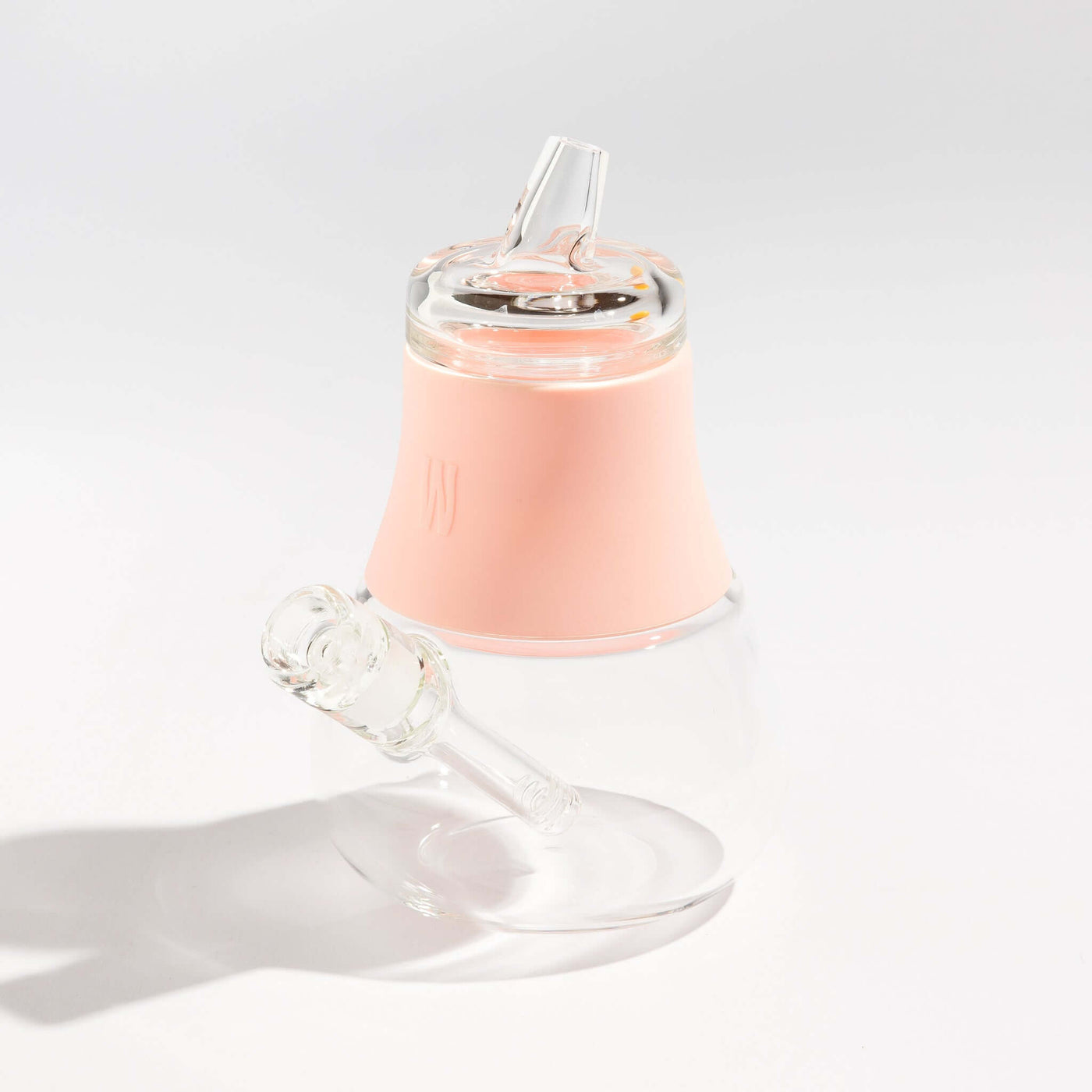 Product photo of a travel-friendly modular glass bubbler with bubblegum pink silicone accents, displayed on a table.