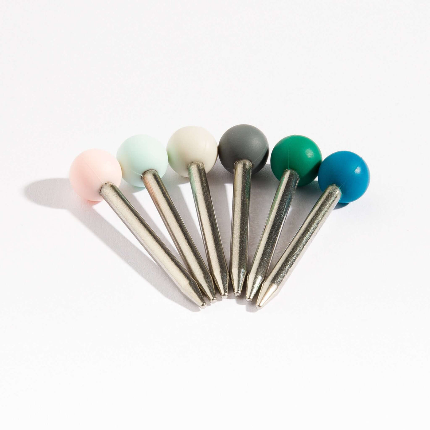 Set of 6 pokers with silicone heads in colorful colors and stainless steel ends on white background.