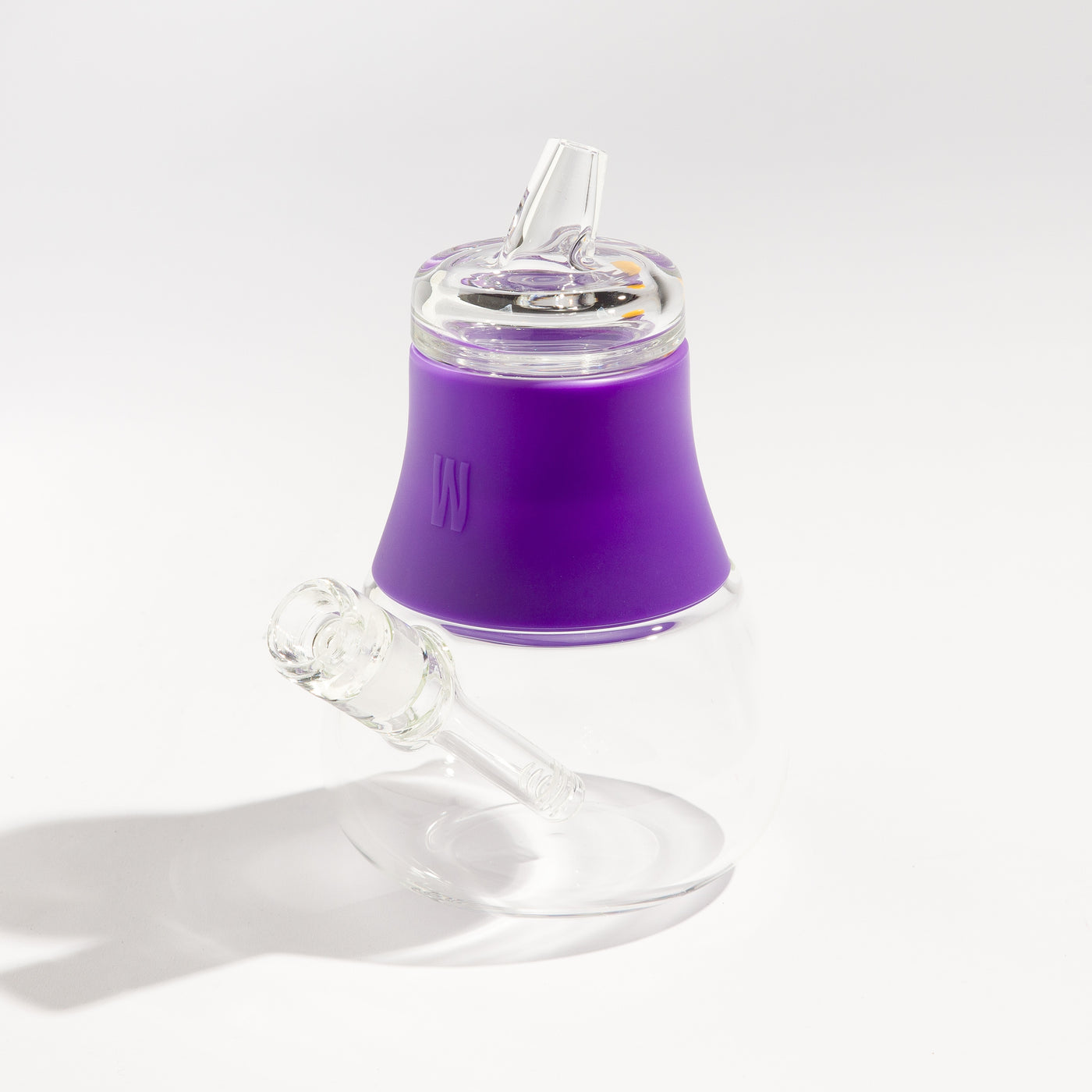 Product photo of a travel-friendly modular glass bubbler with grape purple silicone accents, displayed on a table.