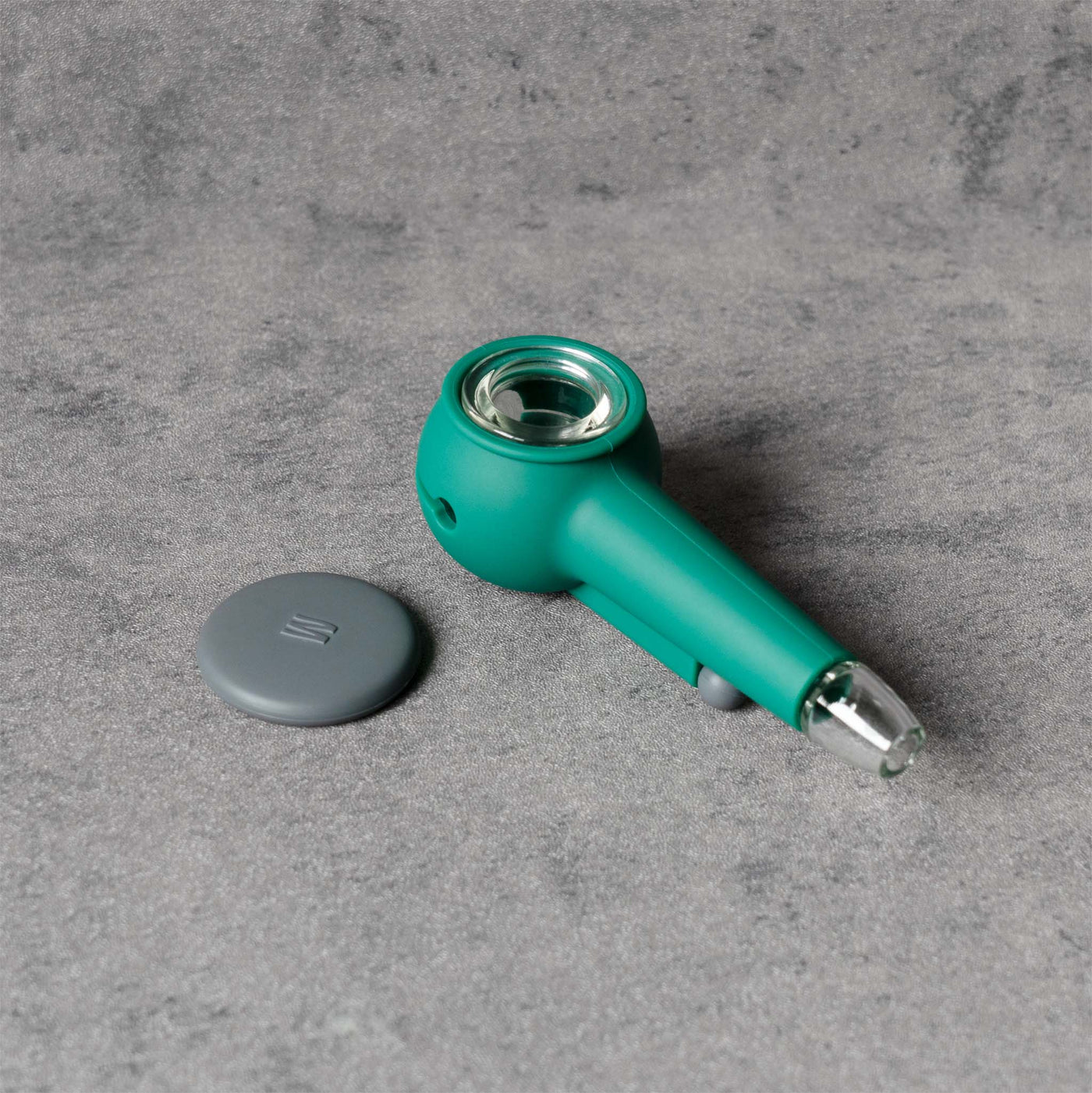 Top view of Weeday forest green silicone pipe with smoke gray lid and clear glass bowl on a textured background.