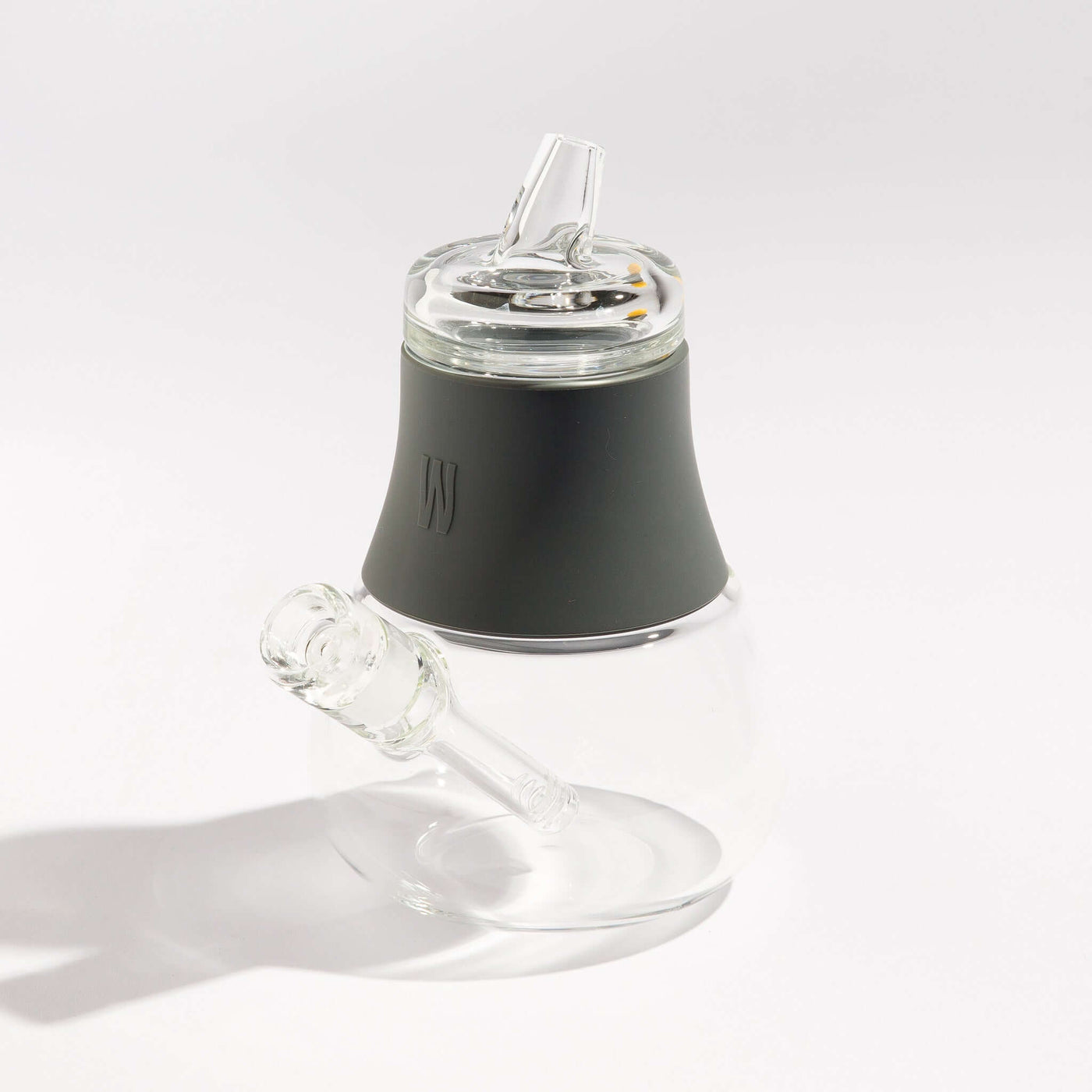 Product photo of a travel-friendly modular glass bubbler with smoke gray silicone accents, displayed on a table.